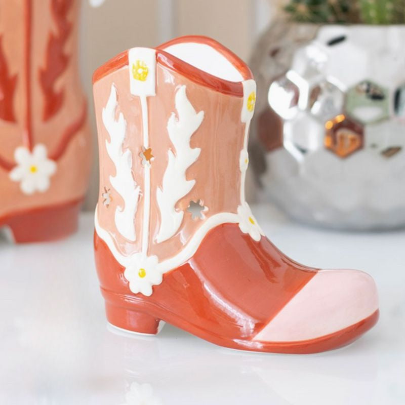 Brule Parfum Far West Botte Western, forme de botte cowboy avec motifs floraux ajourés, présenté dans une ambiance lumineuse et élégante.