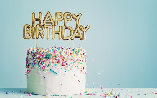 Gâteau d’anniversaire décoré de confettis avec inscription Happy Birthday dans une ambiance festive et colorée.