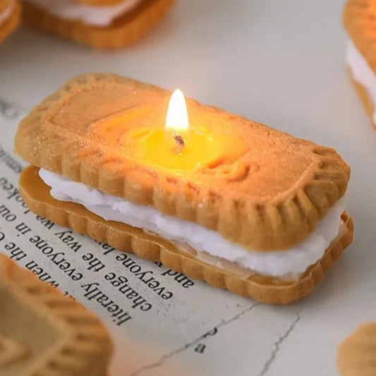 Bougie Décorative Gourmande Sandwich Biscuit, disposée sur une table et la bougie est allumée.