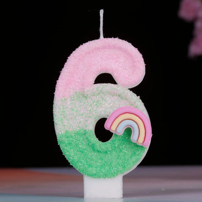 Bougie Anniversaire Arc en Ciel Enchanté, de couleur rose et vert, le chiffre de la bougie est le 6 et sur un fond noir.