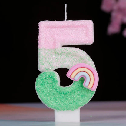 Bougie Anniversaire Arc en Ciel Enchanté, de couleur rose et vert, le chiffre de la bougie est le 5 et sur un fond noir.