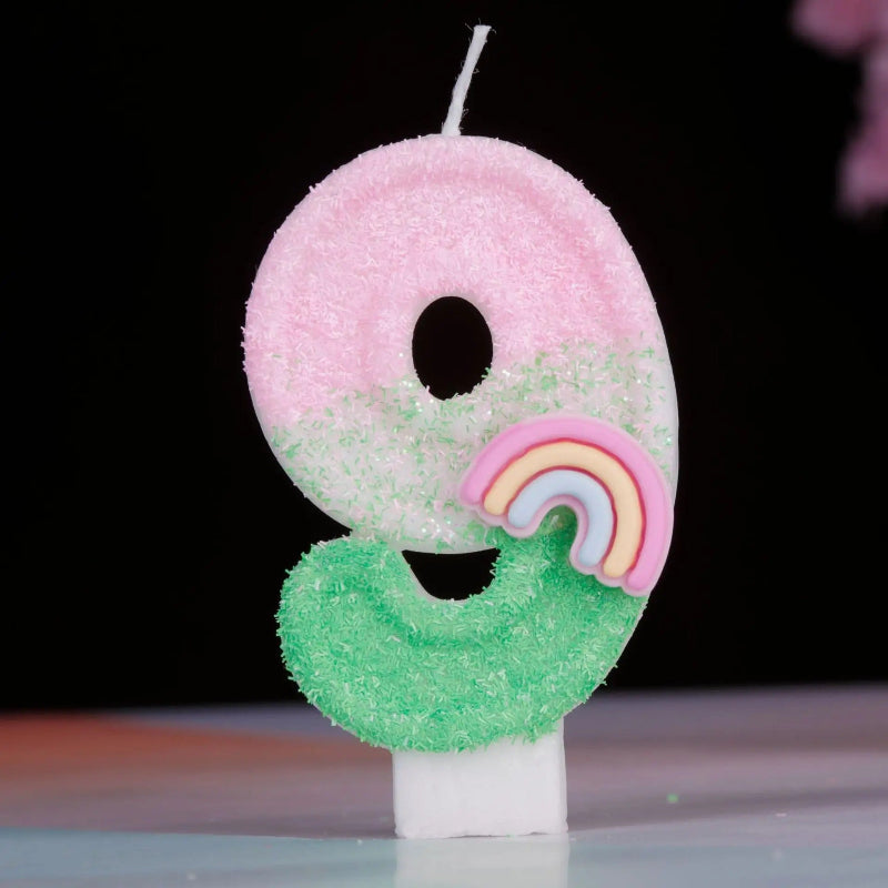 Bougie Anniversaire Arc en Ciel Enchanté, de couleur rose et vert, le chiffre de la bougie est le 9 et sur un fond noir.