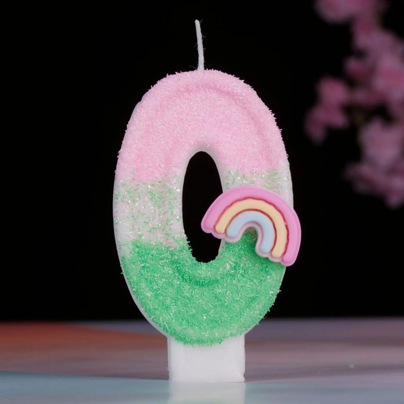 Bougie Anniversaire Arc en Ciel Enchanté, de couleur rose et vert, le chiffre de la bougie est le 0 et sur un fond noir.