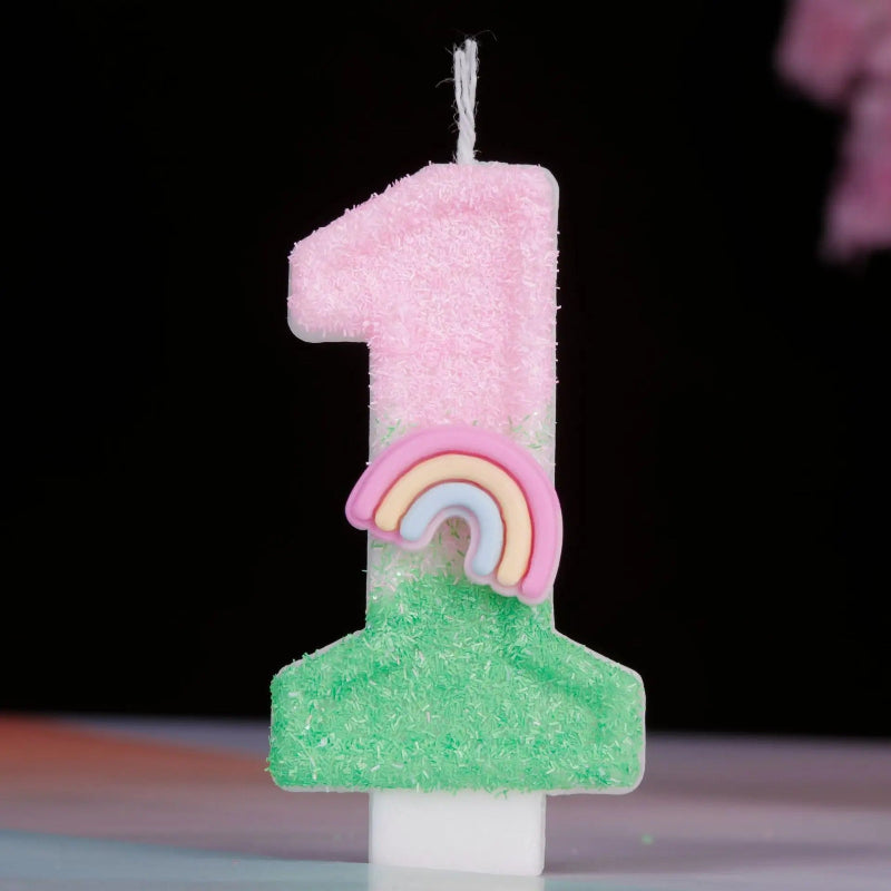 Bougie Anniversaire Arc en Ciel Enchanté, de couleur rose et vert, le chiffre de la bougie est le 1 et sur un fond noir.