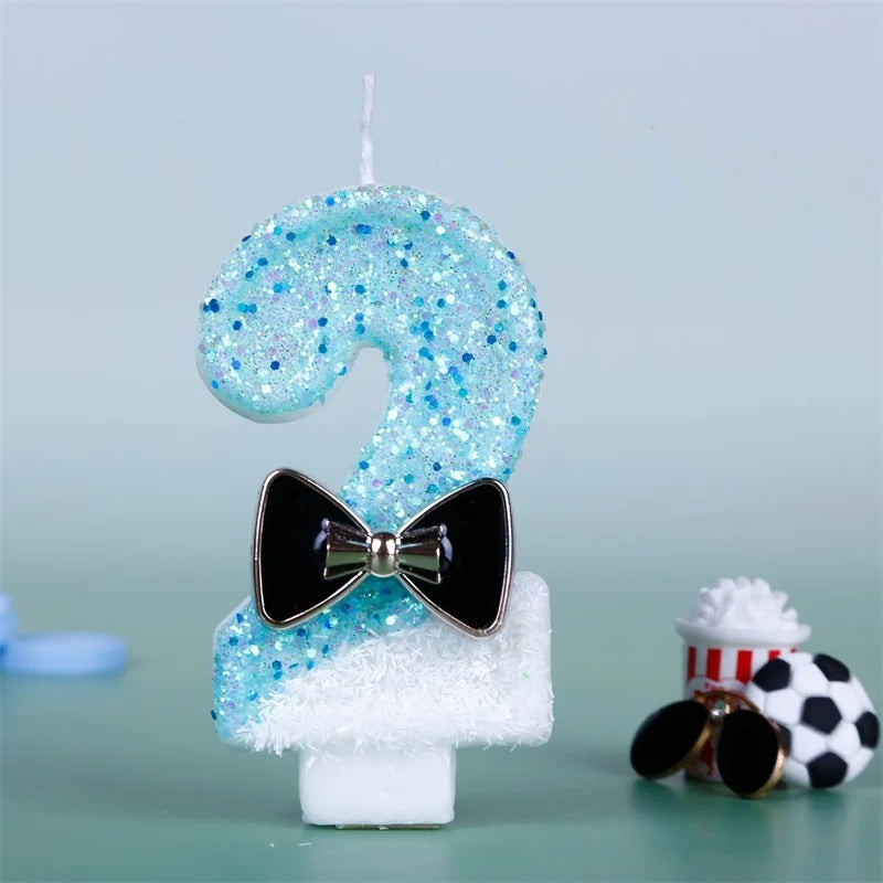 Bougie Anniversaire Charme Scintillant, le chiffre de la bougie est le 2, de couleur bleue et blanche, sur fond bleu pâle.