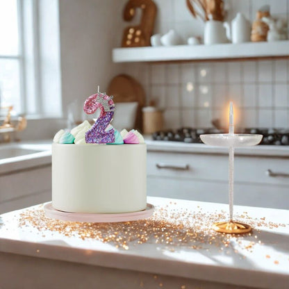 Bougie Anniversaire Couronnée de Lumière, le chiffre de la bougie est le 2, disposée sur un gâteau d'anniversaire posé dans une cuisine moderne.