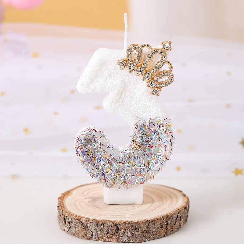 Bougie Anniversaire Édition Prestige, le chiffre de la bougie est le 3, de couleur blanche avec une couronne dorée et posée sur un rondin de bois.