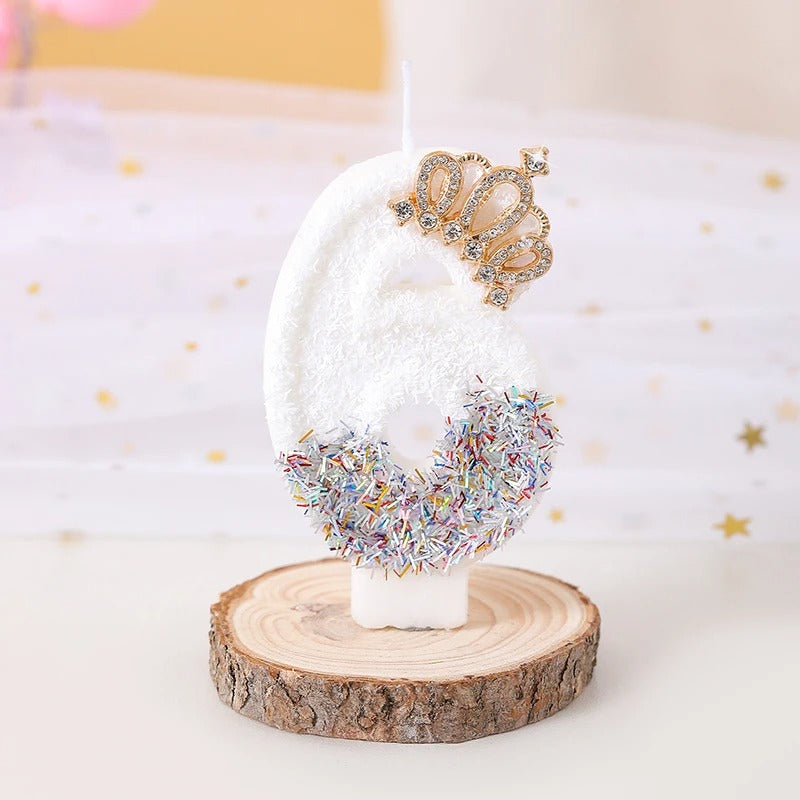 Bougie Anniversaire Édition Prestige, le chiffre de la bougie est le 6, de couleur blanche avec une couronne dorée et posée sur un rondin de bois.