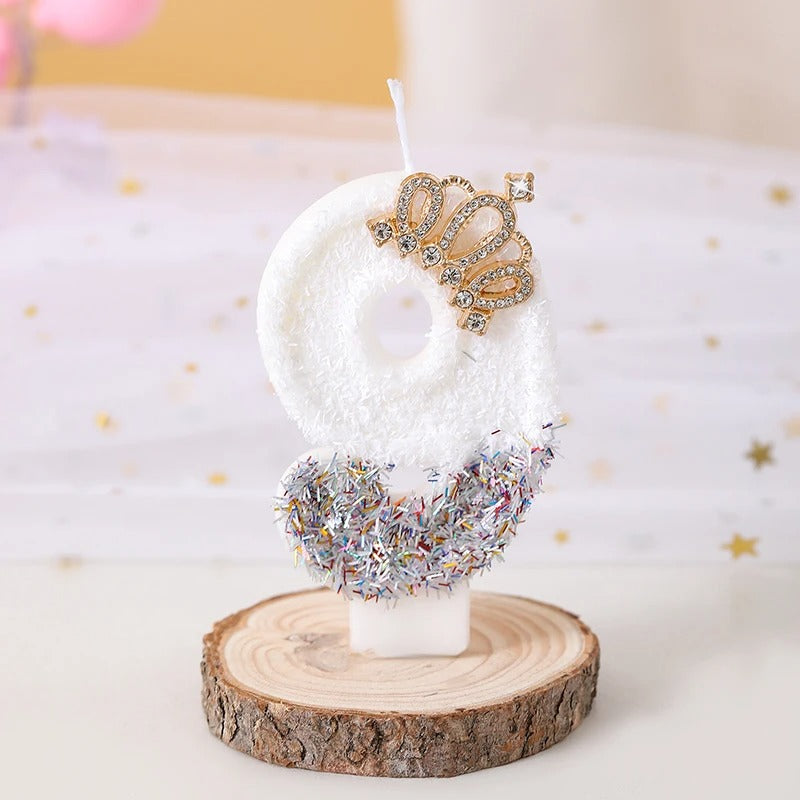 Bougie Anniversaire Édition Prestige, le chiffre de la bougie est le 9, de couleur blanche avec une couronne dorée et posée sur un rondin de bois.