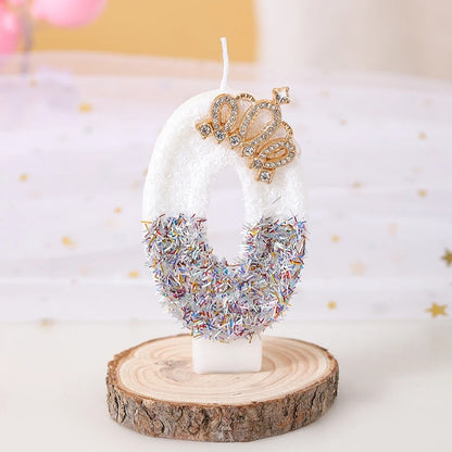 Bougie Anniversaire Édition Prestige, le chiffre de la bougie est le 0, de couleur blanche avec une couronne dorée et posée sur un rondin de bois.