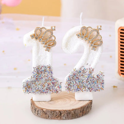 Bougie Anniversaire Édition Prestige, les chiffres représentés sont le 1 et le 2, posés sur un dessous de plat en bois sur un fond blanc cassé.