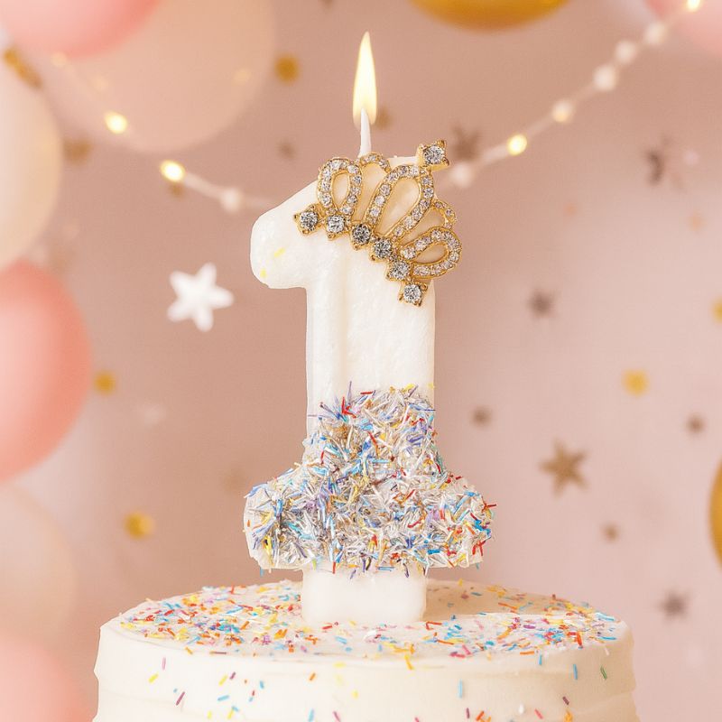 Bougie Anniversaire Édition Prestige, le chiffre de la bougie est le 1, elle est posée sur un gâteau d'anniversaire et dans une ambiance festive.