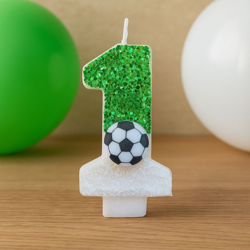 Bougie Anniversaire Fan de Football, de couleur verte, avec son ballon dessus et posée sur une table en bois.