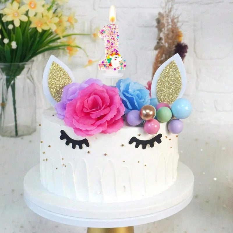 Bougie Anniversaire Licorne Explosion de Paillettes, disposée sur un gâteau d'anniversaire. Le chiffre de la bougie est le 1.