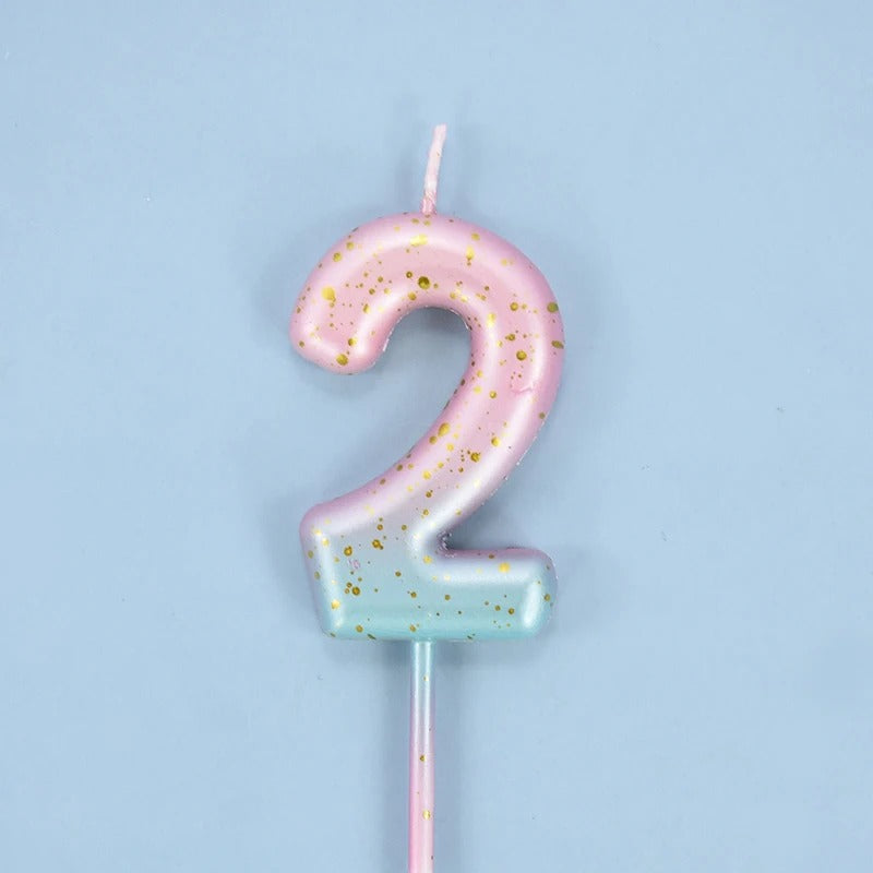 Bougie Anniversaire Look Sucré, de couleur rose et bleu, le chiffre de la bougie est le 2 et sur fond bleu.