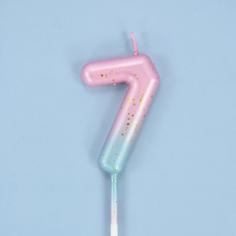 Bougie Anniversaire Look Sucré, le chiffre de la bougie est le 7, de couleur rose et bleu sur fond bleu.