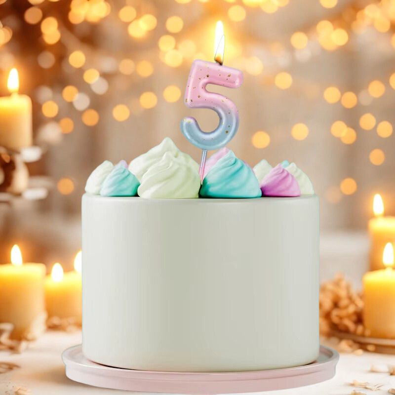Bougie Anniversaire Look Sucré, le chiffre de la bougie est le 5 et de couleur bleue et rose. Disposée sur un gâteau d'anniversaire. Ambiance festive.