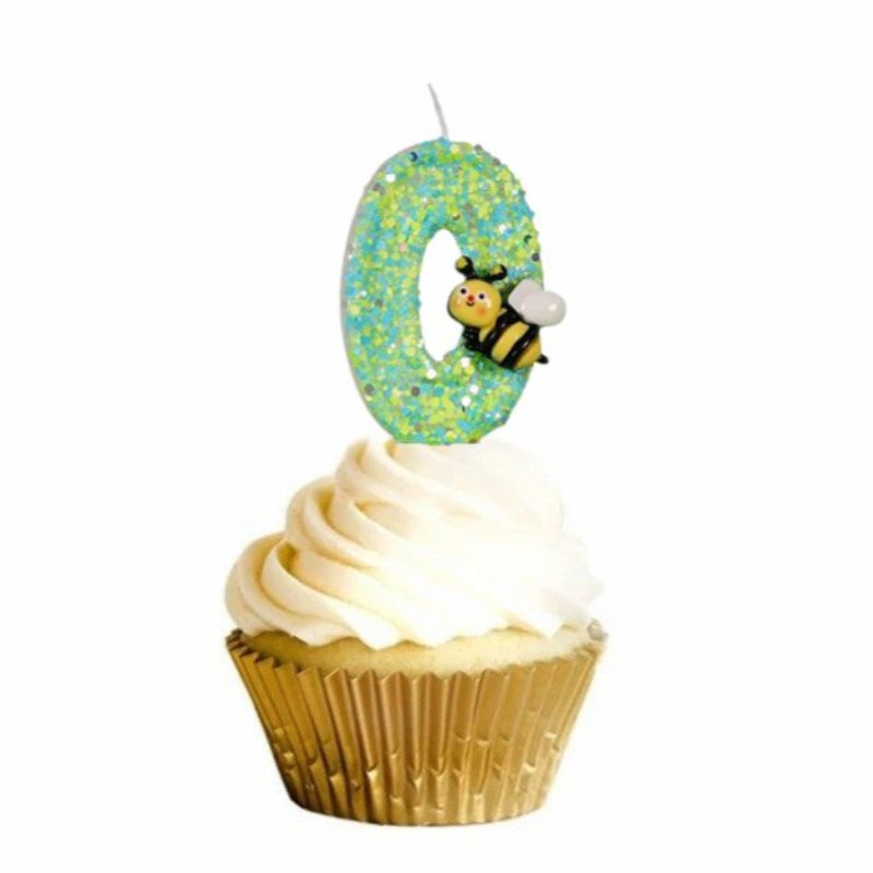 Bougie Anniversaire Magie du Jardin, disposée sur un cupcake, le chiffre représenté est le 0 et sur fond blanc.
