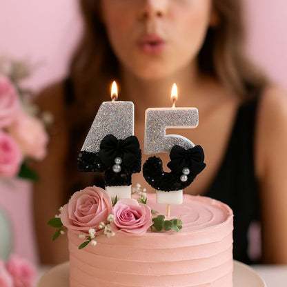 Bougie Anniversaire Nœud Chic, les chiffres sont le 4 et le 5, de couleur noire et argentée, disposées sur un gâteau d'anniversaire chic et une femme est en train de souffler ses bougies.