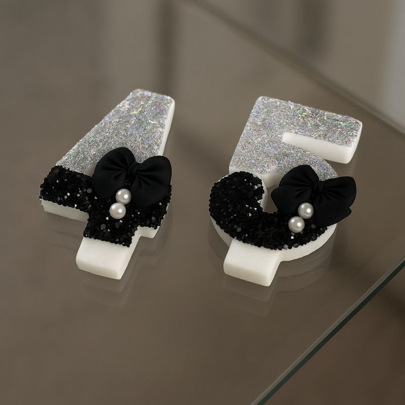 Bougie Anniversaire Nœud Chic, les chiffres sont le 4 et le 5 posées sur une table en verre.