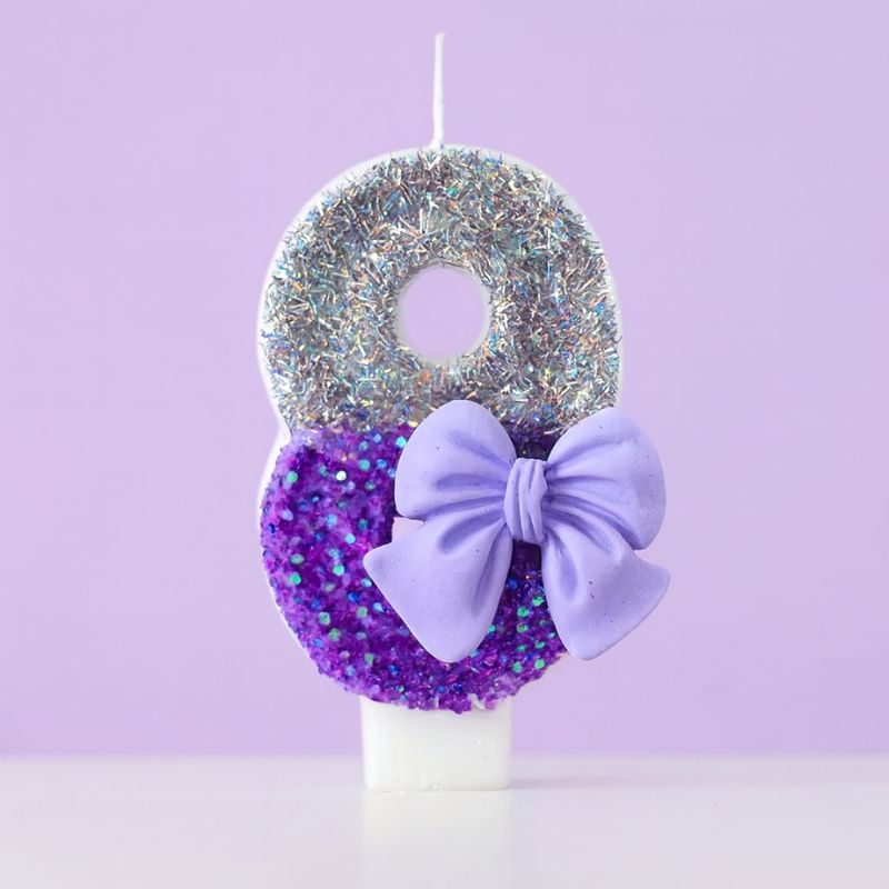 Bougie Anniversaire Noeud Romantique, de couleur violette et argentée, avec un noeud, le chiffre représenté est le 8. Sur fond violet pastel.