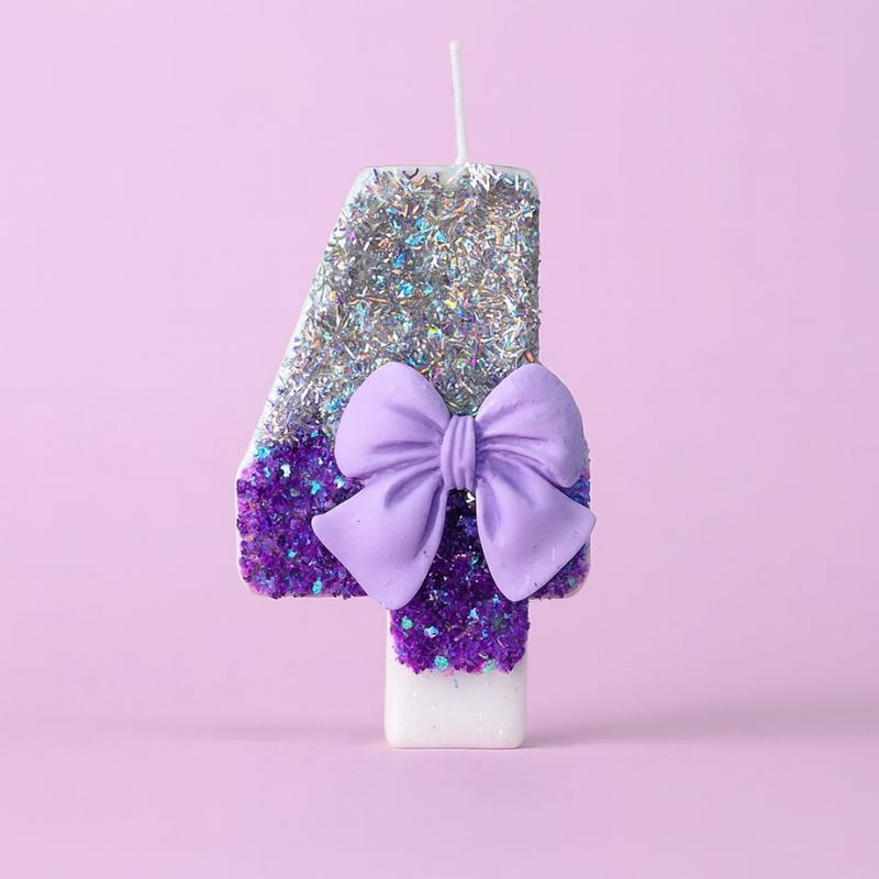 Bougie Anniversaire Noeud Romantique, de couleur violette et argentée, avec un noeud, le chiffre représenté est le 4. Sur fond violet pastel.