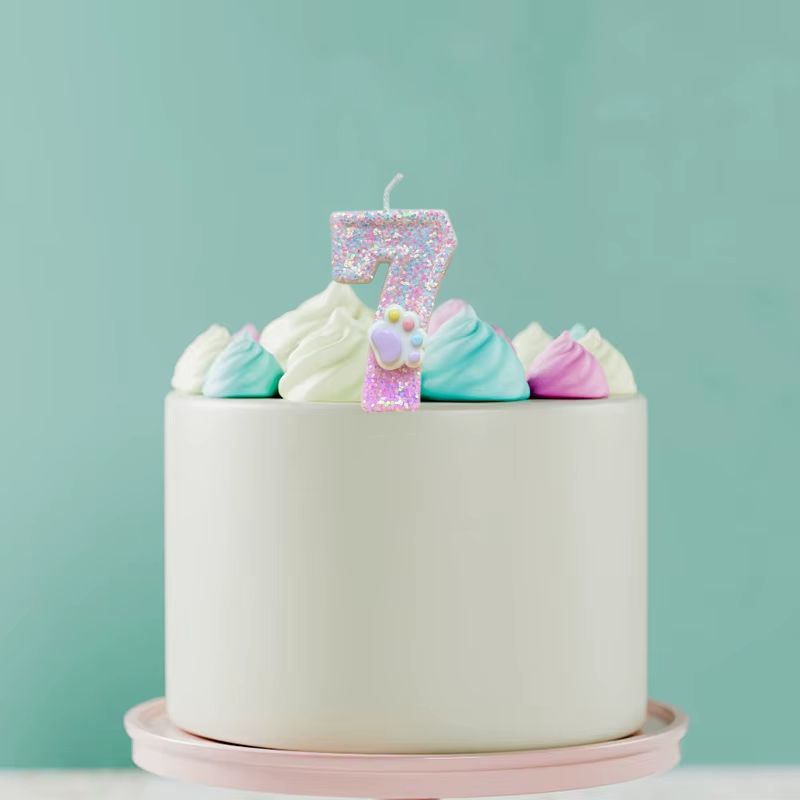 Bougie Anniversaire Patte Féline Scintillante, disposée sur un gâteau d'anniversaire. Le chiffre représenté est le 7.