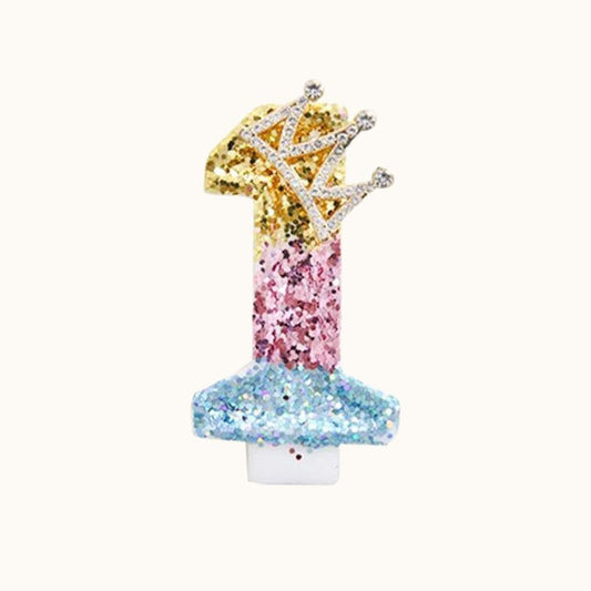 Bougie Anniversaire Reine des Paillettes, multicolore avec une couronne à strass. Le chiffre de la bougie est le 1 et sur fond beige.