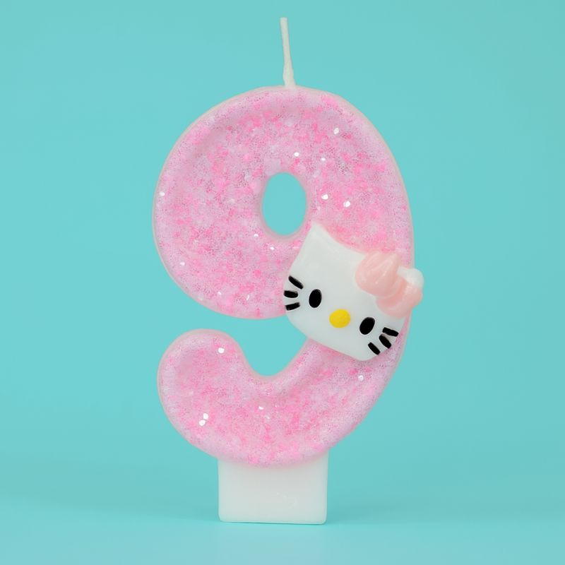 Bougie Anniversaire So Cute, de couleur rose à paillette, le chiffre est le 9 et sur fond turquoise.
