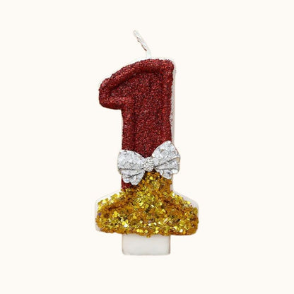 Bougie Anniversaire Style Glamour, le chiffre de la bougie est le 1, de couleur rouge et dorée, sur fond beige clair.