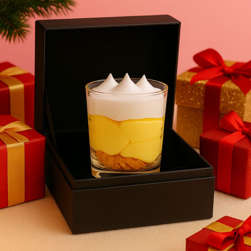 Bougie Bijou Artisanale Gourmande, la bougie est disposée dans un coffret-cadeau noir, ambiance festive.