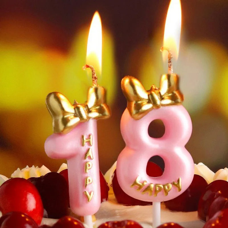 Bougie Chiffre Rose Girly et Chic, le chiffre de la bougie est le 1 et le 8. La bougie est allumée et sur un gâteau.