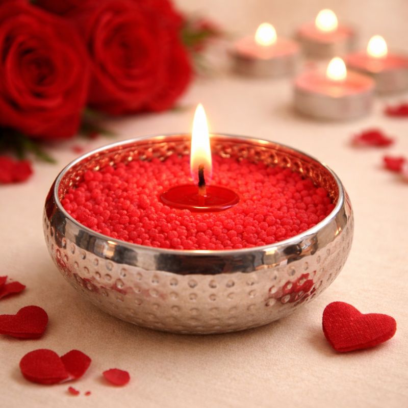 Bougie cire perle rouge bol argenté allumée décoration romantique avec cœurs. Ambiance glamour.
