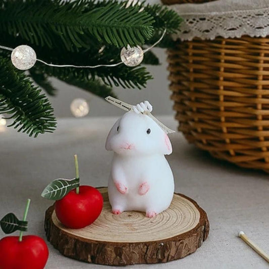 Bougie Décorative Animal Petit Lapin Blanc, disposée sur un plateau en bois avec une ambiance festive.