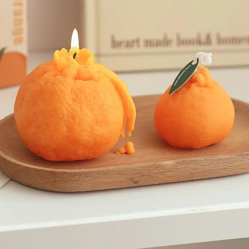 Bougie Décorative Fruit Orange Parfumée, disposée dans un plateau en bois et dans un espace de la cuisine.