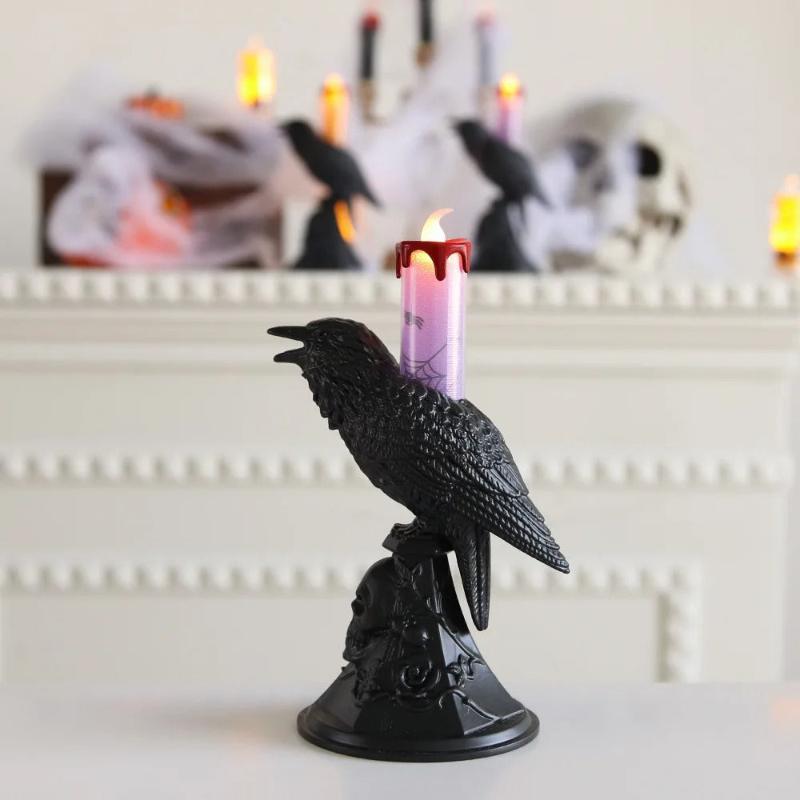 Bougie Halloween Esprit des Ténèbres, en forme de corbeau mais avec la bougie violette, posée sur une table blanche.