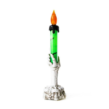 Bougie Halloween Lumière Hantée, de couleur blanche et verte, sur fond gris clair.