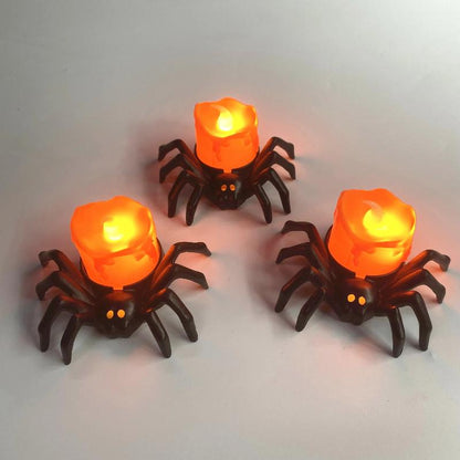 Bougie Halloween Terreur Lumineuse, 3 bougies en forme d'araignée et posée sur une table grise.