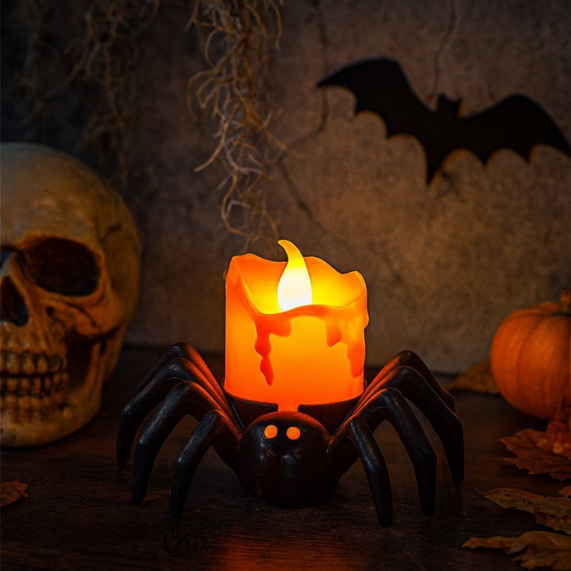 Bougie Halloween Terreur Lumineuse, la bougie est en forme d'araignée en LED et allumée dans un décor effrayant.
