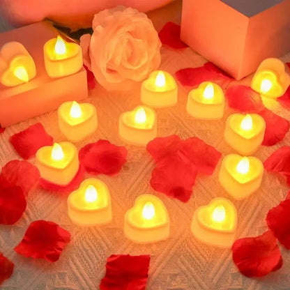 Bougie LED Chauffe Plat Cœur, disposées sur une table aumilieu de pétales de rose rouge.