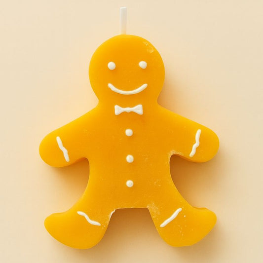 Bougie Noël Bonhomme Pain d’Épices, de couleur orange, forme de bonhomme et sur fond beige.