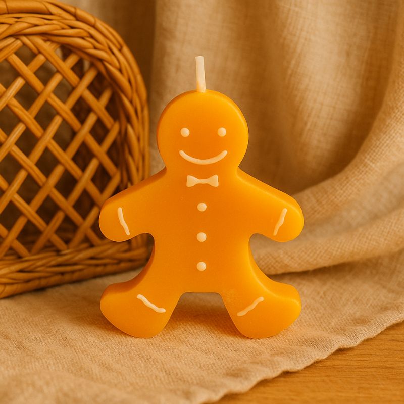 Bougie Noël Bonhomme Pain d’Épices, posée sur un plaid en lin et dans une ambiance cocooning.