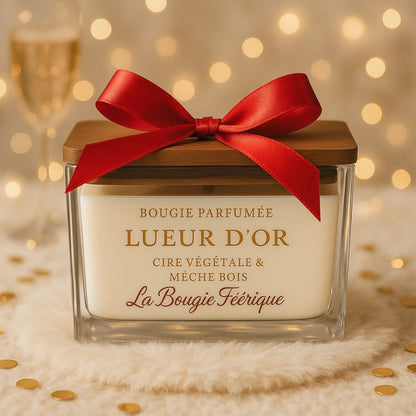 Bougie Parfumé Lueur D'Or, ambiance festive avec un nœud rouge disposé sur la bougie.