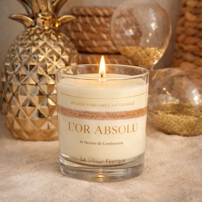 Bougie Parfumée Artisanale L’Or Absolu allumée dans une ambiance chaleureuse et élégante, décor doré et matières naturelles, lumière douce créant une atmosphère cosy et raffinée.