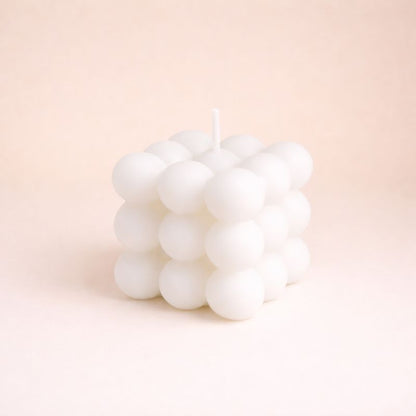 Bougie Parfumée Cube Design, de couleur blanche et de forme bubble carré. Sur fond beige clair.