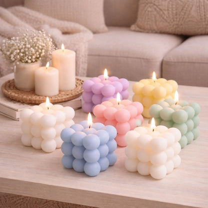 Bougie Parfumée Cube Design, elles sont posées sur une table basse et dans une ambaince scandinave.