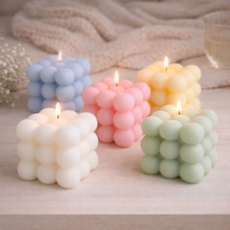 Bougie Parfumée Cube Design, les couleurs representées sont le blanc, vert, bleu, rose et jaune. Ambiance cocooning.