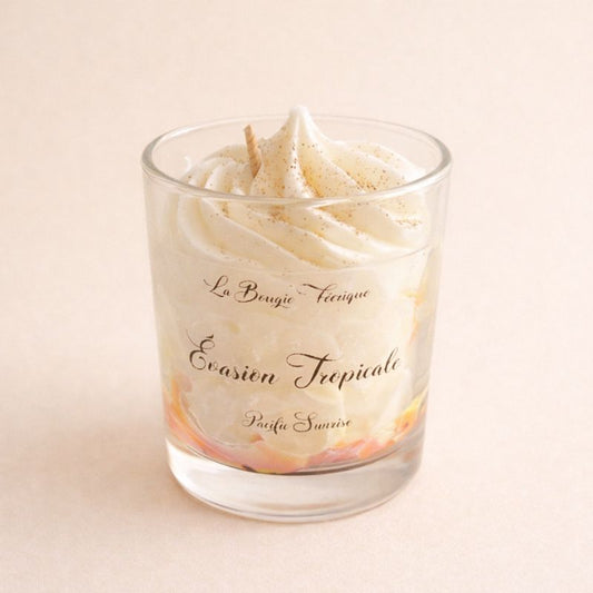 Bougie Parfumée Évasion Tropicale en verre avec effet chantilly et mèche centrale pour une ambiance douce et exotique. Sur fond Beige clair.