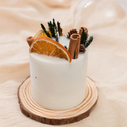Bougie Parfumée Fleur Sèche Pilier Romantique, avec des fruits séchés, sur un rond en bois et sur fond beige.