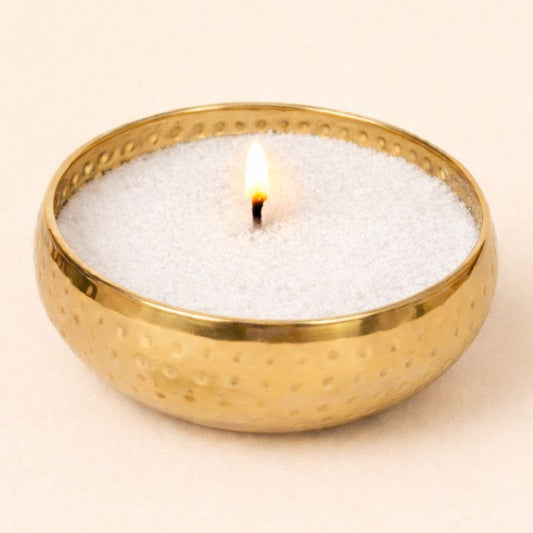 Bougie Perles Combo Doré, contenant de couleur doré, cire végétale blanche avec une meche et allumée, sur fond beige clair.